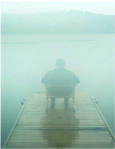 Man overlooking lake in fog